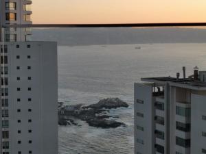 维纳德马Exquisito Departamento Reñaca en el sector más turístico的从两栋建筑中欣赏到海景