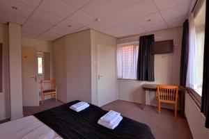 a bedroom with a bed with two towels on it at Royal in Deventer