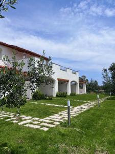 uma casa com um caminho de pedra em frente a um quintal em Sa Jacca Albergo Rurale em Siniscola