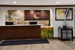 een kantoorlobby met een receptie en een bakstenen muur bij Comfort Inn & Suites Fishers - Indianapolis in Fishers