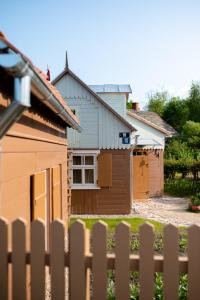 una casa con una valla delante de ella en i’dille Brīvdienu māja, en Kuldīga