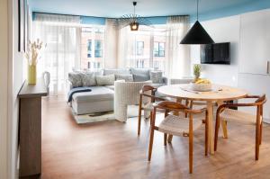 - un salon avec une table et un canapé dans l'établissement Seehuus Duhnen Apartments, à Cuxhaven