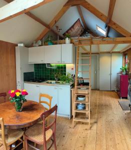 een keuken met een tafel en een ladder in een kamer bij Garden house Zuiderwoude in Zuiderwoude