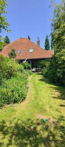 een huis met een grasveld ervoor bij Garden house Zuiderwoude in Zuiderwoude