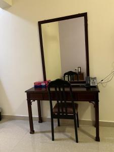 a desk with a mirror and a chair in a room at Ibra Plaza Hotel in Ibrā