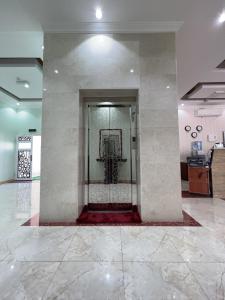 a lobby with a glass door in a building at Ibra Plaza Hotel in Ibrā