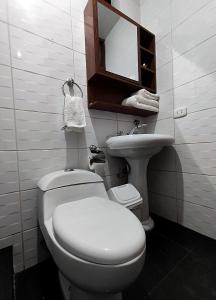 La salle de bains est pourvue de toilettes blanches et d'un lavabo. dans l'établissement El Balcón del Sol, à Cusco