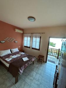 um quarto com uma cama e uma grande janela em Villa Sunray em Agios Ioannis Pelio