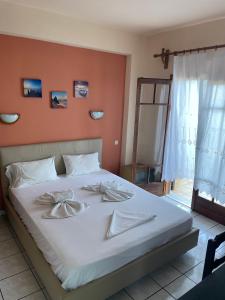 um quarto com uma cama grande e lençóis brancos em Villa Sunray em Agios Ioannis Pelio