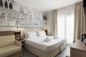 um quarto de hotel com uma cama e uma cadeira em Hotel Marco Polo em Lido di Jesolo