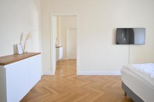 a bedroom with a bed and a television on a wall at Osteiner Hof by The Apartment Suite in Mainz