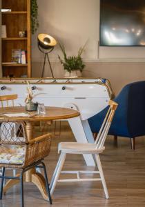 d'une table, de chaises et d'un bureau blanc. dans l'établissement Kyriad Lyon Est - Bron Eurexpo Le Cottage, à Bron