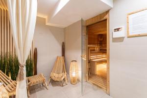 a room with a balcony with chairs and a glass door at Qubus Hotel Gdańsk in Gdańsk