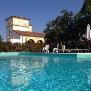 a swimming pool in front of a building with a clock tower at Residence Cà Beregana in Vicenza