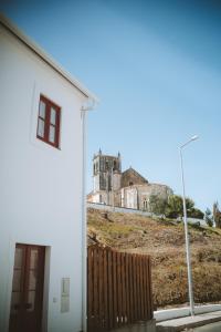 ein weißes Gebäude mit einem Schloss im Hintergrund in der Unterkunft Casa do Castelo in Lourinhã