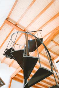 eine Wendeltreppe aus Metall, die von einer Holzdecke hängt in der Unterkunft Casa do Castelo in Lourinhã