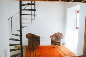 2 Stühle in einem Zimmer mit Wendeltreppe in der Unterkunft Casa do Castelo in Lourinhã