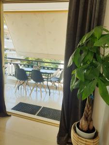 une salle à manger avec une table, des chaises et une plante dans l'établissement EcoStay-Scandy,2bdr cozy apartment by the sea in Alimos, à Athènes