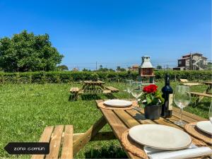 een houten picknicktafel met borden en wijnglazen bij La Maruca Beach Santander 3000 in Santander