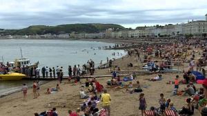 duża grupa ludzi na plaży w obiekcie Elsinore Hotel Llandudno w mieście Llandudno