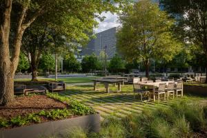 um parque com mesas e cadeiras e um edifício em Houston CityPlace Marriott at Springwoods Village em The Woodlands