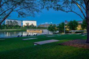 um parque com um lago e um edifício em Houston CityPlace Marriott at Springwoods Village em The Woodlands