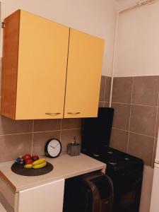 a kitchen with a clock and fruit on a counter at Mini studio aproape de centru in Bucharest