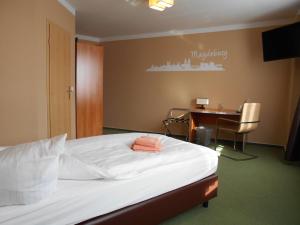 sypialnia z łóżkiem, biurkiem i stołem w obiekcie Síu Hotel Magdeburg w mieście Magdeburg