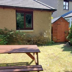 una panchina di legno seduta di fronte a una casa di Aviemore Bungalow, Dalfaber ad Aviemore