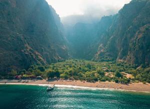 Butterfly Valley Beach Glamping with Food في أولدينيس: قارب على نهر في وادي جبلي