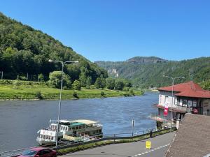 フジェンスコにあるPension Jitřenka Hřenskoの川の上の建物の隣に停泊している船