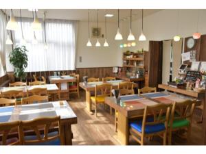 restauracja z drewnianymi stołami, krzesłami i światłami w obiekcie Fujieda Ogawa Hotel - Vacation STAY 20866v w mieście Fujieda