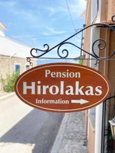 een bord waarop staat dat pensioen hirudasinformatie hangt aan een gebouw bij Pension Hirolakas in Galaxidhion