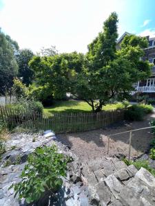 una recinzione con un albero in un giardino di L’Al Golette a Namur