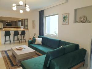 - un salon avec un canapé vert et une table dans l'établissement EcoStay-Scandy,2bdr cozy apartment by the sea in Alimos, à Athènes