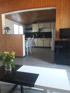 a living room with a table and a kitchen at MADALNY HOUSE in La Garnache