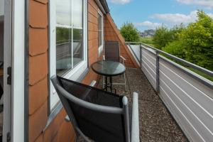 een balkon met een tafel en een stoel erop bij Boutique 54° Nord in Büsum