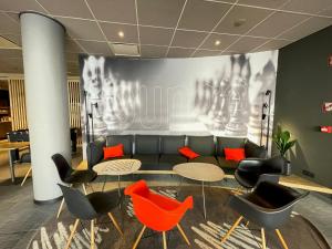 a lobby with tables and chairs and a couch at ibis Gent Centrum St. Baafs Kathedraal in Ghent