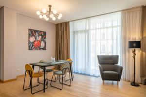 een woonkamer met een eettafel en stoelen bij Easyrooms Dzirnavu in Rīga