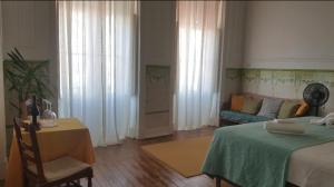 een slaapkamer met een bed, een tafel en een bank bij OlhãOmirante Guesthouse in Olhão