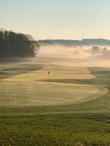 un campo da golf nebbioso con una bandiera in primo piano di Luxus_EG_Fewo TEE ONE a Göhren-Lebbin