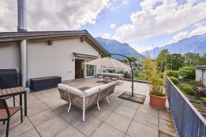 patio ze stołem, krzesłami i górami w obiekcie Terrace Vista Interlaken w mieście Interlaken