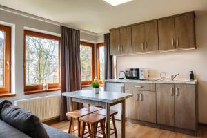 a kitchen with wooden cabinets and a table in a room at DW Pod Jaworami - relaks w SPA - jacuzzi, sauna na wyłączność in Białka Tatrzanska