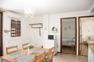 a kitchen and dining room with a table and chairs at Csillagvirág Apartman Gyula in Gyula