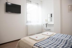 a white room with a bed with two towels on it at Csillagvirág Apartman Gyula in Gyula