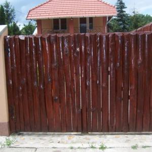 una recinzione di legno di fronte a una casa di Sweet Home Apartman a Hajdúszoboszló