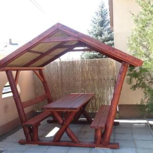 un tavolo da picnic in legno con tetto su un patio di Sweet Home Apartman a Hajdúszoboszló