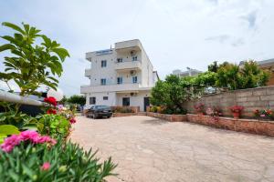 un bâtiment avec une voiture garée devant lui dans l'établissement Guest House Gerard, à Ksamil