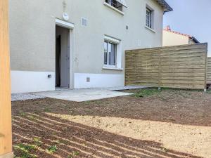 una casa con una valla de madera delante de ella en Résidence Appartements Niort wifi-parking, en Niort