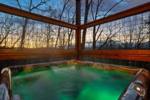 een jacuzzi in een huis met bomen bij Mountain Retreat Game Room, BBQ, & Scenic Views in Sevierville